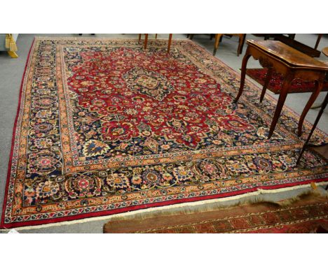 A Mashad carpet, North West Iran, the raspberry field of vines around an indigo medallion framed by spandrels and indigo bord