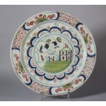 An 18th century English delft charger with building and grass decoration, 11 5/8" dia (restored)