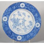 An 18th century London delft plate with scratched and reserved flower decoration, Oriental figure in