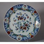 An 18th century Bristol delft charger with spray of flowers and insect decoration, monogram "WP" for