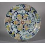 An 18th century English delft charger with central flower decoration, 13 1/8" dia (glaze faults