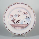 An 18th century English delft plate with manganese and blue line landscape and building decoration