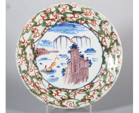 An 18th century English delft plate with polychrome landscape with rock and boat decoration and "gate" border, 8 7/8" dia (cr