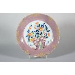 An 18th century London delft shallow bowl with central polychrome rock and flower decoration and