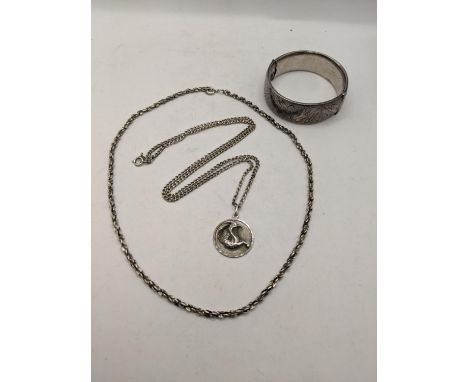 A silver bangle having engraved detail, along with two silver necklaces, total weight 73.5g Location: 