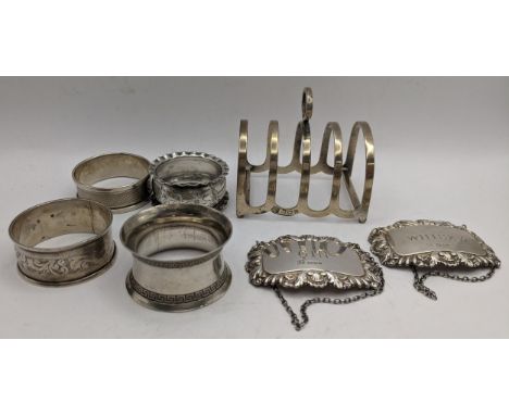 Silver to include four napkin rings and a pair of decanter labels and a toast rack 127gLocation: 