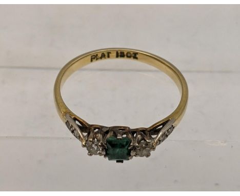 An 18ct gold and platinum ring set with emerald flanked by diamonds, total weight 2.1g Location: 