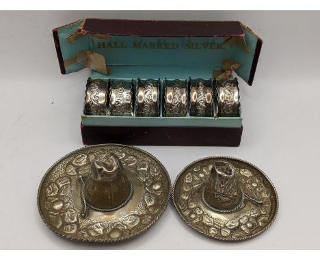 A boxed set of six silver embossed napkin rings, hallmarked Birmingham 1903, 47.8g together with two Mexican white metal somb