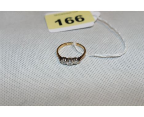 A three stone diamond ring, the centre stone 0.25 carat approx. in gold marked 18ct. Size O