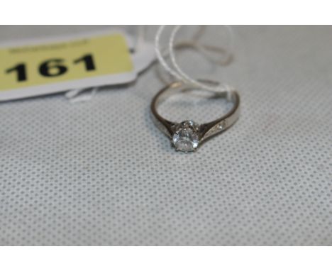 A diamond solitaire ring, the stone 0.75 carat approx., two diamonds to each shoulder. In white gold marked 750. Size Q