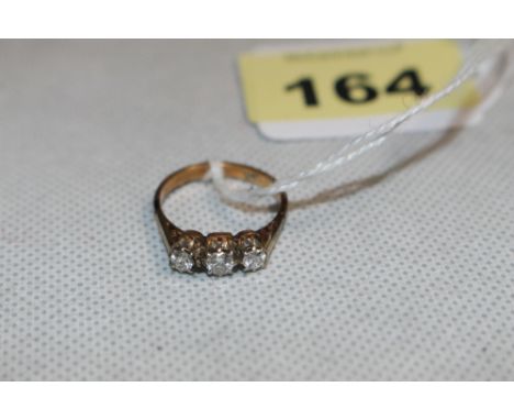 A three stone diamond ring, the centre stone 0.25 carat approx. In gold marked 18ct. Size N