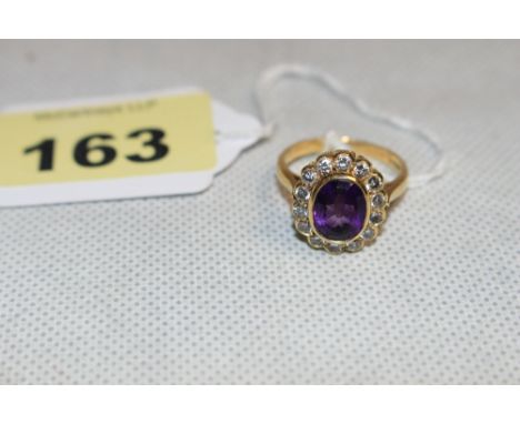 An amethyst and fourteen diamond cluster ring, the centre stone 9.5mm high. In gold marked 750. Size Q