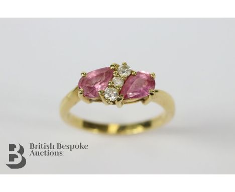 18ct ruby and diamond ring. The ring set with two tear-form rubies approx 4 x 6mm, stamped 750, London hallmark, size J, appr