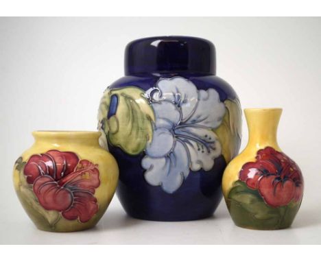 Moorcroft ginger jar and cover and two small vases, decorated with hibiscus on a mid blue and green grounds, impressed and pa