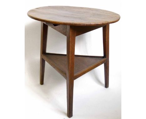 Oak cricket table, the circular plank top on three legs and triangular uniting shelf, diameter 70cm.