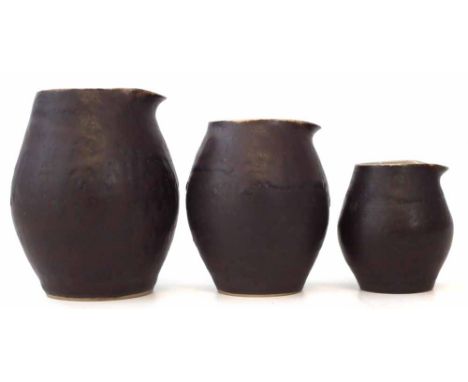 Lucie Rie (1902 - 1995) graduated set of three jugs, with brown exteriors and pale grey interiors, monograms to each base, th