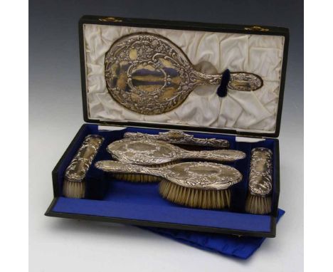 Cased silver backed dressing table set, J&R Griffin, Chester 1908, embossed with foliage, of two pairs of brushes, comb and h