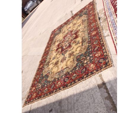 A modern Persian carpet decorated central floral medallion and spandrels on a beige ground with three border stripes, 138" x 