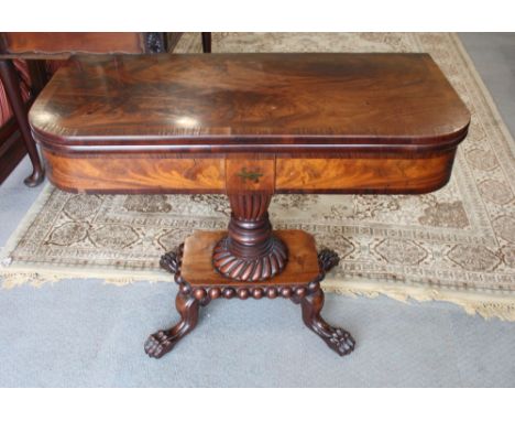 An early 19th Century crossbanded mahogany fold-over top card table with brass inlaid frieze, on vase turned central column a