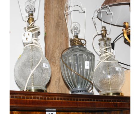 A pair of baluster bodied glass and gilt metal table lamps with cracked ice design and a similar wired glass table lamp