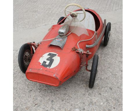 A child's Tri-ang metal pedal operated racing car, painted red, and a child's scooter