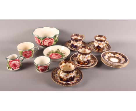 Five Wemyss pieces and a number of Staffordshire coffee cups and saucers decorated in navy and gold with flowers