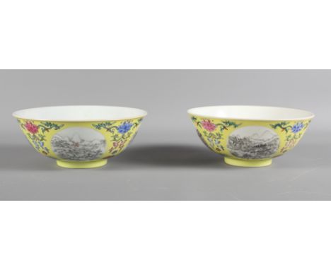 A pair of Chinese porcelain bowls, each decorated with four landscape reserves between floral motifs on a yellow ground with 