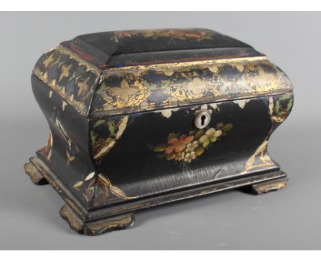 A 19th Century sarcophagus-shaped black papier mache tea caddy decorated with flowers and gilt, 8" wide