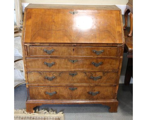 An early 18th Century walnut bureau with sloping flap and inlaid herringbone stringing and four graduated drawers below, on b