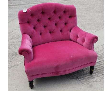A Victorian button back armchair, upholstered in a pink velvet, on ebonised supports