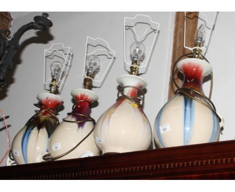 Two pairs of ceramic table lamps with baluster bodies decorated, red, blue and brown streaked glazes