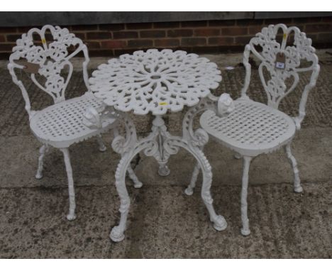 A pair of white painted cast aluminium garden chairs and a similar table