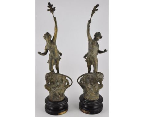 A pair of Art Nouveau spelter figures on circular ebonised wood base, 'Le Pouvoir', a female atop a lion , with oak leaf in l
