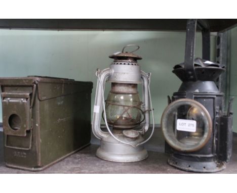 A vintage ammo box, and two hanging lanterns, one bearing the broad arrow