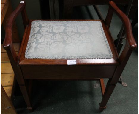 An Edwardian mahogany music stool, with upholstered seat, having hinged lid to the music storage