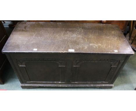 A reproduction oak coffer, with twin decorative panelled front, raised on bracket supports, 95cm wide