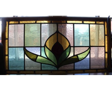A stained glass panel in a pine frame
