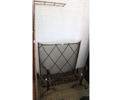 A pair of wrought iron fire dogs, spark guard, brass fender &amp; fire tools