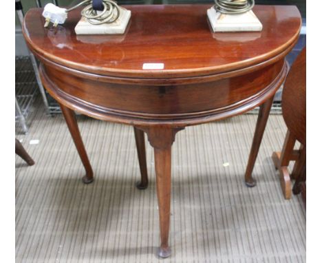 A Georgian mahogany fold over tea &amp; card table, raised on pad foot supports, 73cm dia