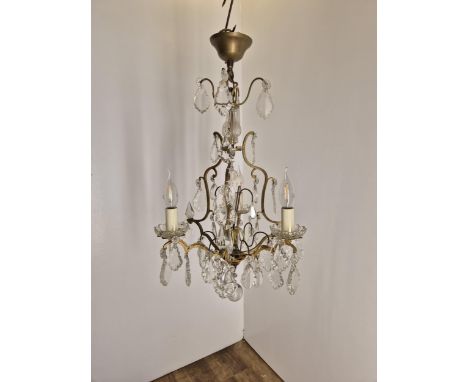 A French gilded three light chandelier with crystal drops, circa 1930's, wired, overall 68cm high, 39cm wide. Condition- fair