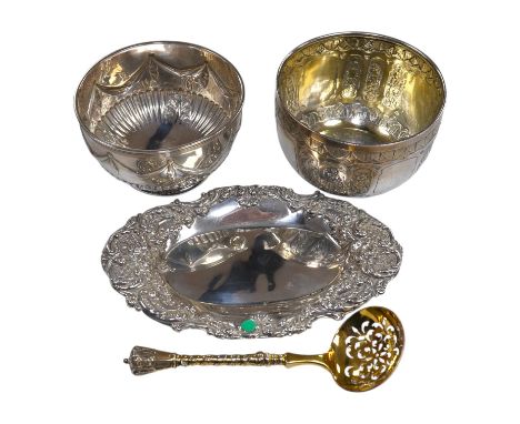 Two Victorian silver sugar bowls, a Victorian silver gilt sifter ladle and a repousse silver dish, 11.8oz. Condition - fair t