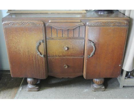 FURNITURE/ HOME - A vintage oak art deco sideboard with cupboards & 3 drawers on ball feet with carved decoration. Measures 1