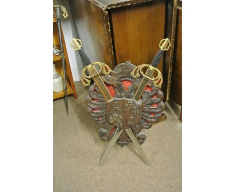 COLLECTABLES - A vintage decorative shield with crossed swords, measuring 74cm tall.