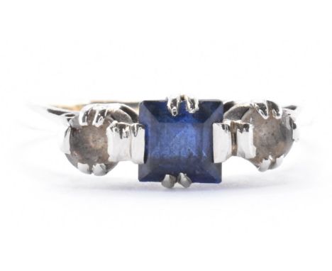 A 9ct gold synthetic sapphire and white stone ring. The ring marked 9ct to the shank with an emerald cut synthetic sapphire f