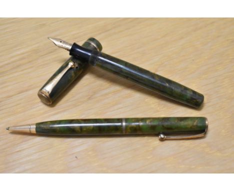 A Parker Moderne Duette Jr button fill fountain pen and propelling pencil set in green and gold marble with single band to th