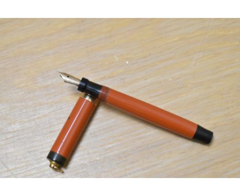 A Parker Lady Duofold Lucky Curve button fill fountain pen in red with broad band to a ring cap having Parker Duofold 14k 5-9