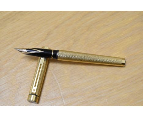 A Sheaffer Targa 1009 converter fill fountain pen in gold with engine turned decal having Sheaffer USA 585 14k nib