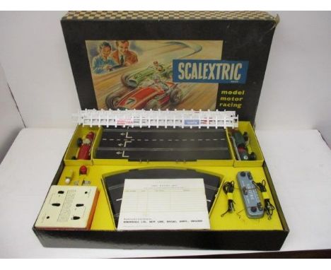 A late 1950s Scalextric boxed set with tin plate cars, track, box to house, the batteries with connectors, a pure silicon ski