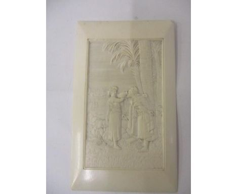 An early 20th century Eastern carved ivory panel depicting a woman feeding water to a traveller by a well and trees, 5" x 3" 
