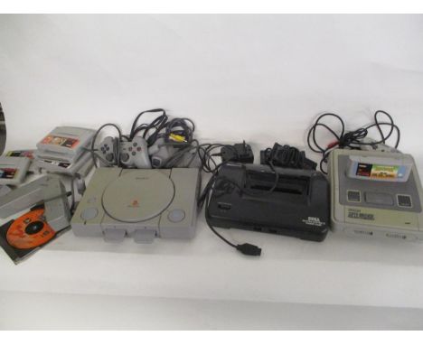 A Playstation console 1, an early Amstrad game console GX4000 and a Super Nintendo game consol and a selection of games 